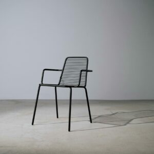 A minimalist metal chair in a studio setting casting a shadow, perfect for design concepts.