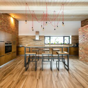 Spacious kitchen interior with industrial design, featuring brick walls and wooden accents.